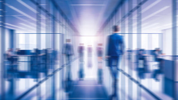 istock Business people walking in office, blurry working space with defocused effect, blurred motion business background 2152377417