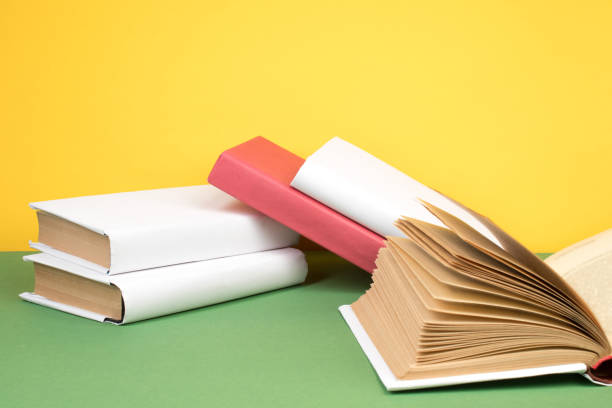 istock Books stacking. Open hardback books on wooden table and green background. Back to school. Copy space for ad text. 2152377504