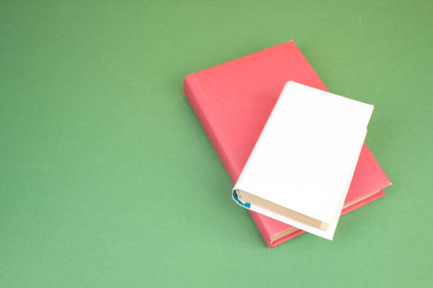 istock Books stacking. Open hardback books on wooden table and green background. Back to school. Copy space for ad text. 2152378782
