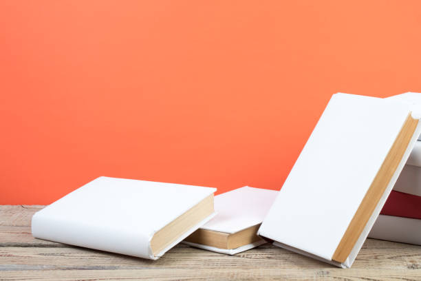 istock Books stacking. Books on wooden table and orange background. Back to school. Copy space for ad text. 2152379582