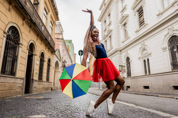 Happy young girl of Indian ethnicity with multicolor umbrella, she looking at camera, front view on white background.