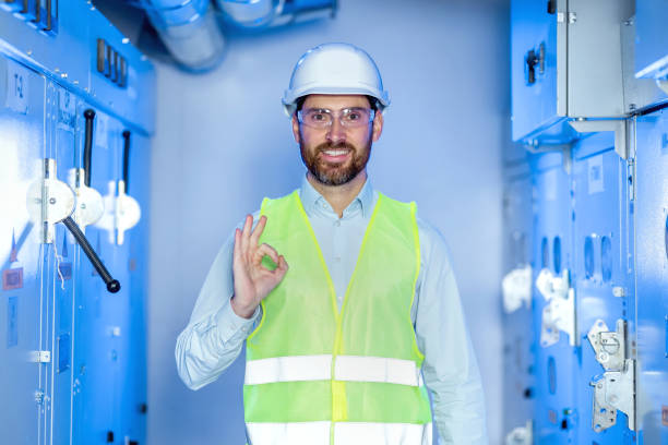 istock Young handsome technician man wearing uniform and security helmet smiling positive doing ok sign with hand and fingers. Successful expression. 2152388177