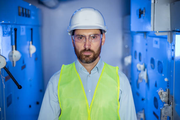 istock Portrait of serious confident young Caucasian engineer worker with beard in protective goggles in industry 2152388182