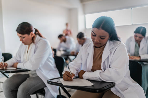 istock Young medical student woman doing educational exam on classroom at university 2152388203
