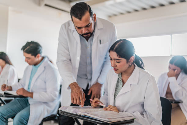 istock Mature medical professor helping student during  class at university 2152389989