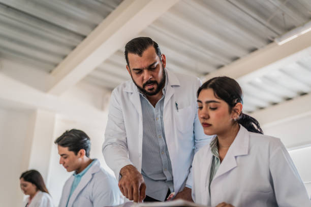 istock Mature medical professor helping student during  class at university 2152389991