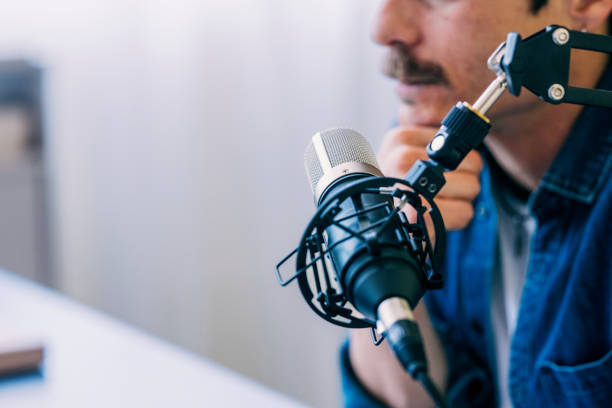 Focused Male Podcaster Recording with Professional Microphone