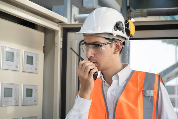 istock Portrait Asia male engineer in protective workwear is checking a electrical control cabinet or circuit electric control button with at rooftop building 2152401130