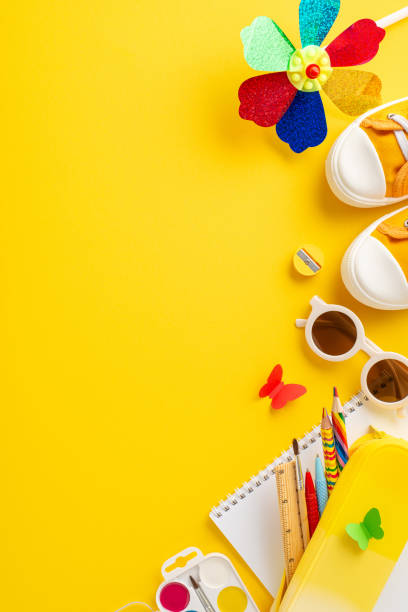 istock A vertical cheerful summer-themed educational setup featuring colorful school supplies and children's accessories displayed on a vibrant yellow background, ideal for educational promotions 2152401446