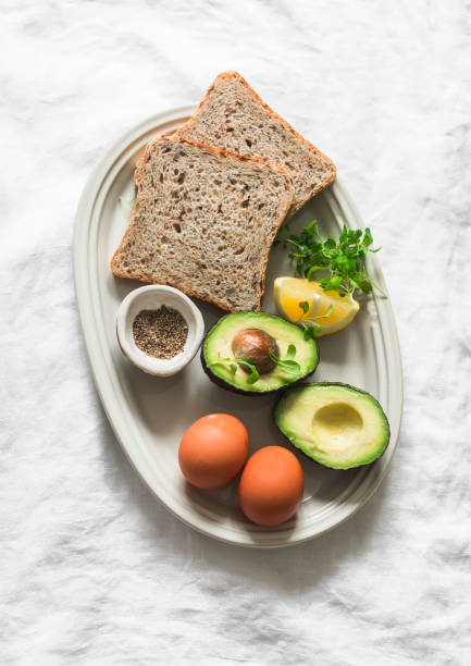 istock Ingredients for making a wholegrain sandwich with avocado, scrambled eggs and microgreens on a light background, top view 2152415796