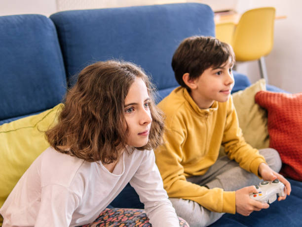 istock Children Playing Video Games on Blue Couch 2152424357