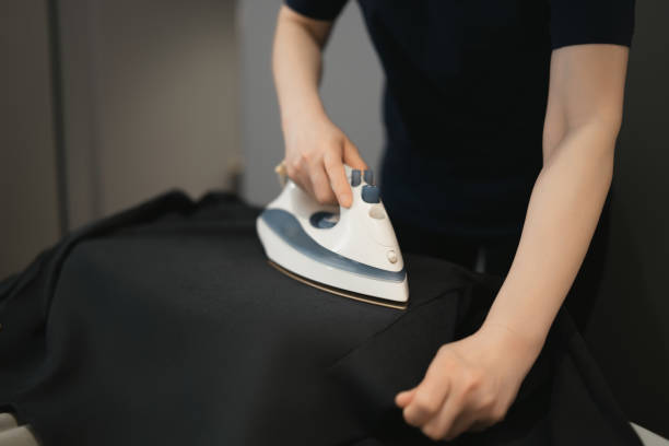 istock Achieving Smooth Elegance with Expert Ironing on Black Fabric 2152424997