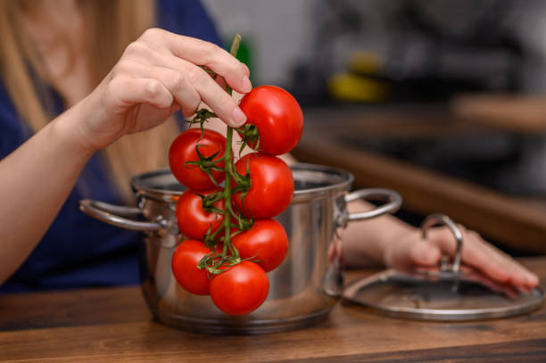 istock Fresh tomatoes on a branch, next to a pot, cooking 2152425240