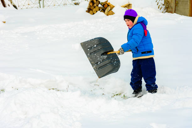 istock Little boy with big shovel removes snow after a snowstorm. 2152425961