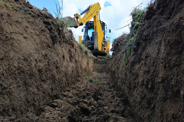 istock A yellow excavator digging a trench on the construction site, a close-up, against the sky. 2152426459