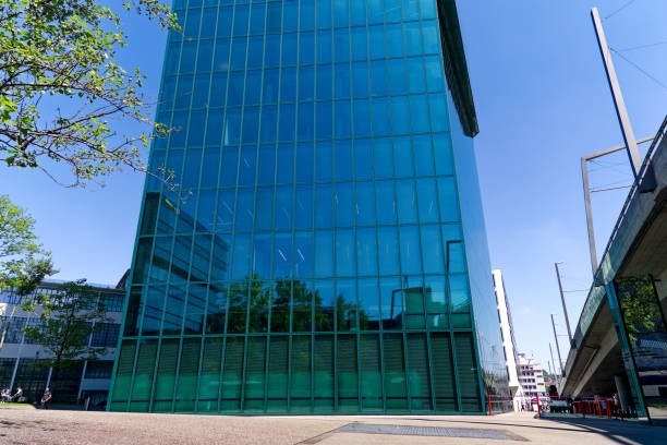 Scenic view of green blue glass facade of famous Prime Tower skyscraper with people walking at Swiss City of Zürich on a sunny spring noon. Photo taken May 10th, 2024, Zurich, Switzerland.