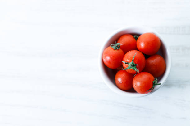 istock red cherry tomato in white ceramic bowl on white background 2152434746