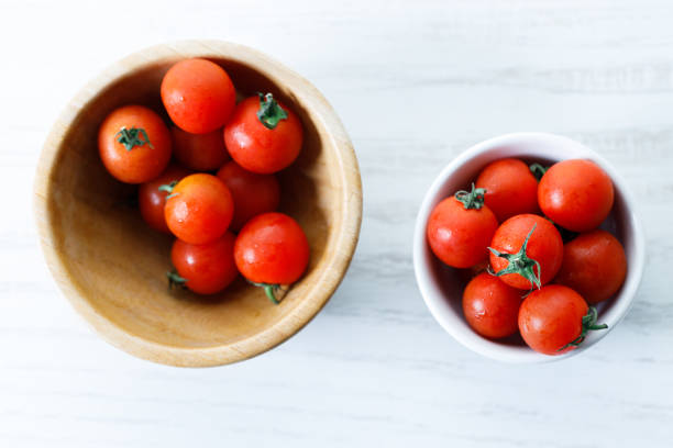 istock red cherry tomato in white ceramic bowl on white background 2152434761
