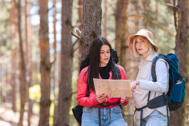 istock Two female hikers looking at a map in the woods 2152441088