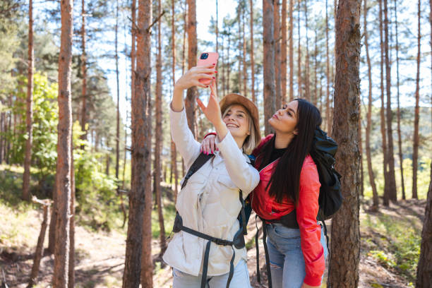 istock Two beautiful young hikers taking selfies in the woods 2152441624