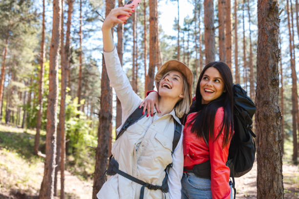 istock Two beautiful young hikers taking selfies in the woods 2152441633