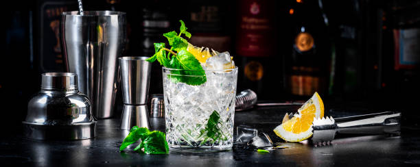 istock Summer refreshing drink cocktail with mint, lemon, vodka and gin tonic. Dark background bar counter, banner 2152444344