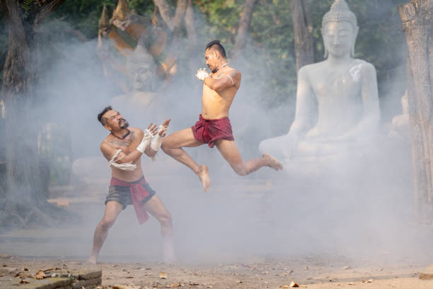 Asian man practicing Muay Thai, traditional Thai boxing With the backdrop of an ancient temple in Thailand, exercise concept.