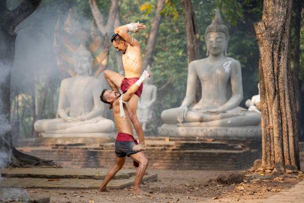 Cinematic scene of traditional Muay Thai warriors sparring in front of elephant in rural Thailand