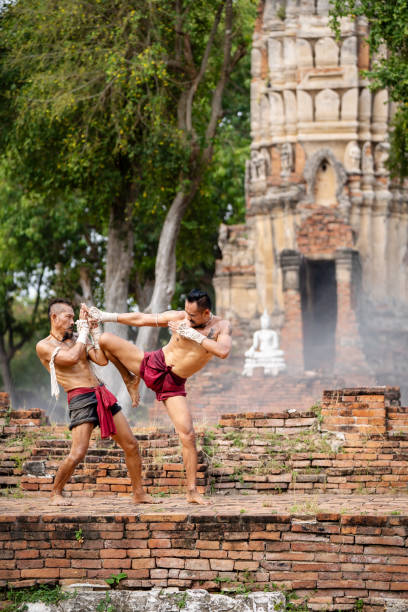 istock Asian man practicing Muay Thai, traditional Thai boxing With the backdrop of an ancient temple in Thailand, exercise concept. 2152444592