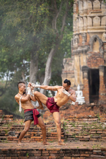 istock Asian man practicing Muay Thai, traditional Thai boxing With the backdrop of an ancient temple in Thailand, exercise concept. 2152444594