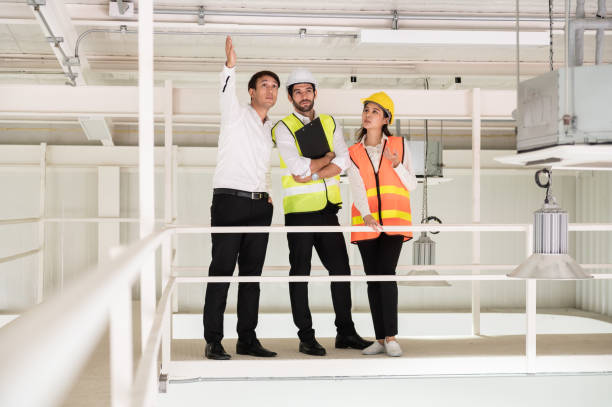 istock Young Asian engineer or building inspector checking interior building detail with female construction worker by using check list and drawing. Two building worker inspecting interior building. 2152448831