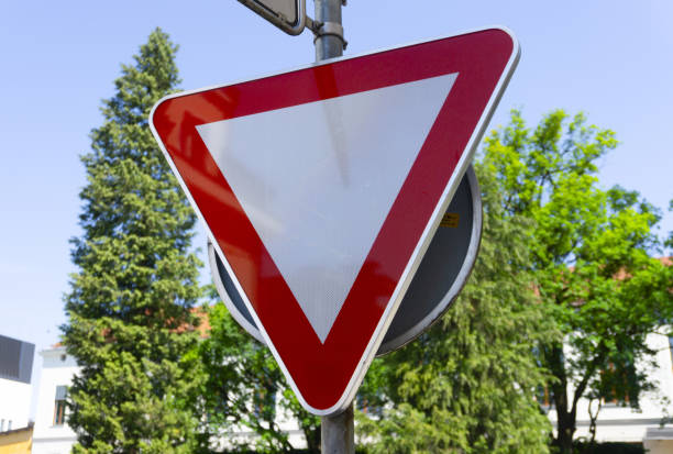 A red-bordered white triangular yield sign is mounted above a rectangular sign displaying \