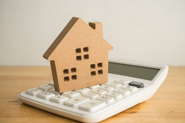 istock Wooden house on white calculator background copy space. 2152451286