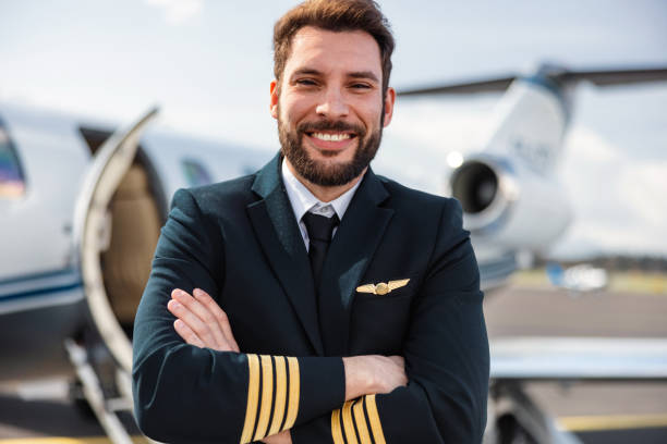 istock Confident Male Pilot in Uniform Posing in Front of a Private Jet 2152454850