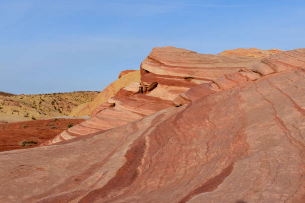 Scenic view of striated red and white rock formations along the White Domes Hiking Trail in Valley of Fire State Park in Mojave desert, Nevada, USA. Unique natural landmark shaped like a spire