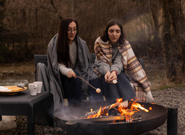istock young women are roasting marshmallows on a fire outdoors 2152462151