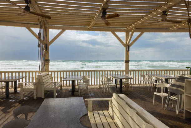 istock wooden tables with benches and a canopy on the seashore 2152465931