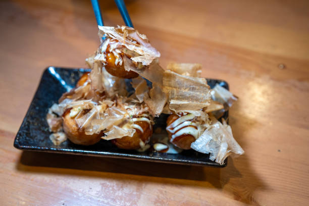 Takoyaki is a popular Japanese street food Takoyaki is a popular Japanese street food consisting of small, round balls of batter filled with pieces of octopus cooking takoyaki is a ball shaped japanese snack stock pictures, royalty-free photos & images