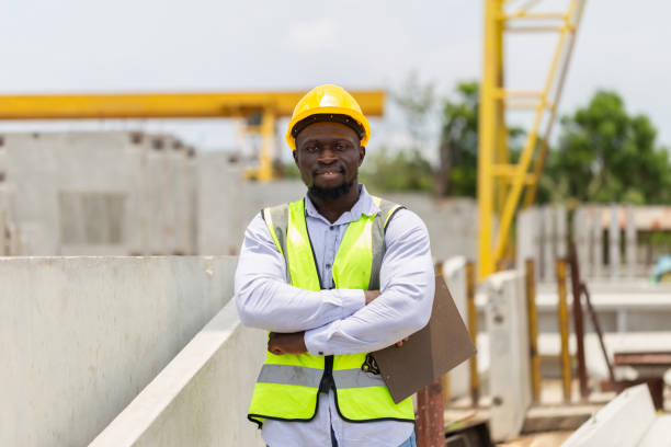 istock Engineer man standing and looking at camera with smiling and arms crossed at construction site, Factory worker man in hardhat with crossed arms 2152471294