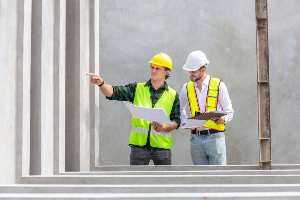 istock Engineer and foreman worker checking project at precast factory site, Engineer and builders in hardhats discussing on construction site 2152473070