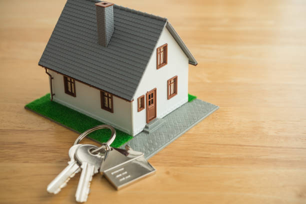 istock House model and key on wooden table background with copy space. 2152475013