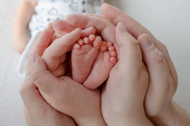 istock Newborn Baby'S Legs In Parents' Hands 2152475527