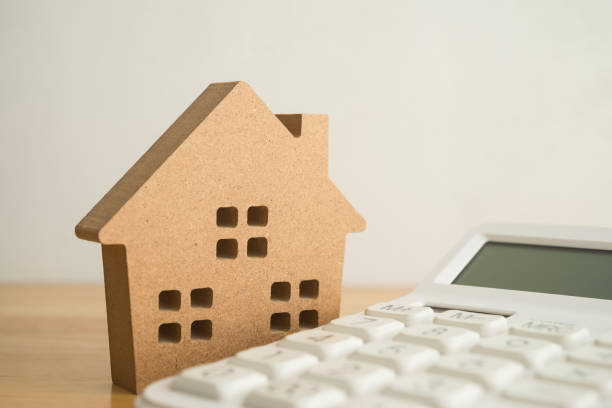 istock Wooden house on white calculator background copy space. 2152476579