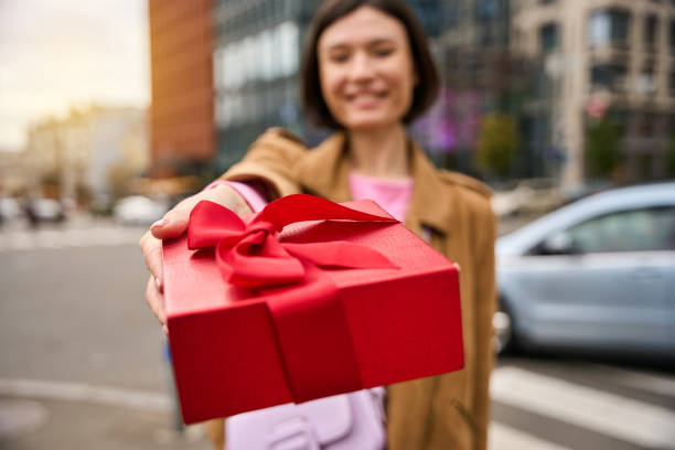 istock Happy pretty woman giving red present box 2152482405