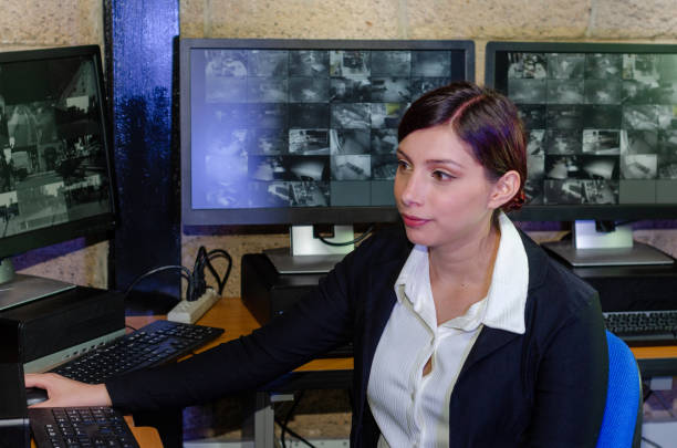 istock Young woman working on surveillance control room looking the monitors at the security office 2152483967