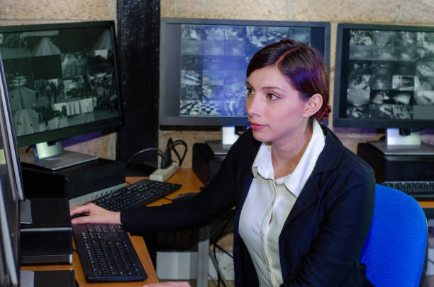 istock Young woman working on surveillance control room looking the monitors at the security office 2152483969
