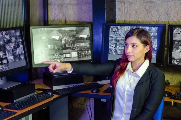 istock Young woman working on surveillance control room looking the monitors at the security office 2152483978