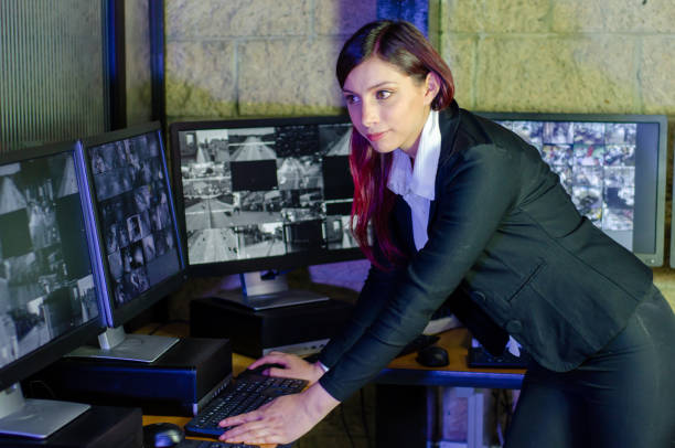 istock Young woman working on surveillance control room looking the monitors at the security office 2152483979
