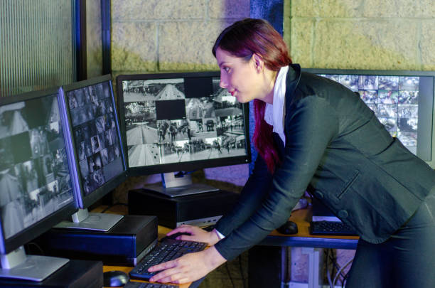 istock Young woman working on surveillance control room looking the monitors at the security office 2152483986