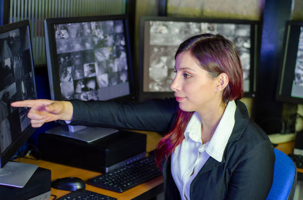 istock Young woman working on surveillance control room looking the monitors at the security office 2152483990